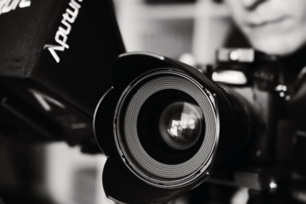 Videokamera und Person beim Filmen, symbolisch für professionelle Videocontent-Produktion